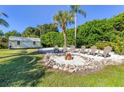 Sandy beach area, complete with firepit and swaying palms at 2102 Dakota Ave. Englewood FL 34224 - Single Family Home for sale at 2102 Dakota Ave, Englewood, FL 34224 - MLS Number is D6121750